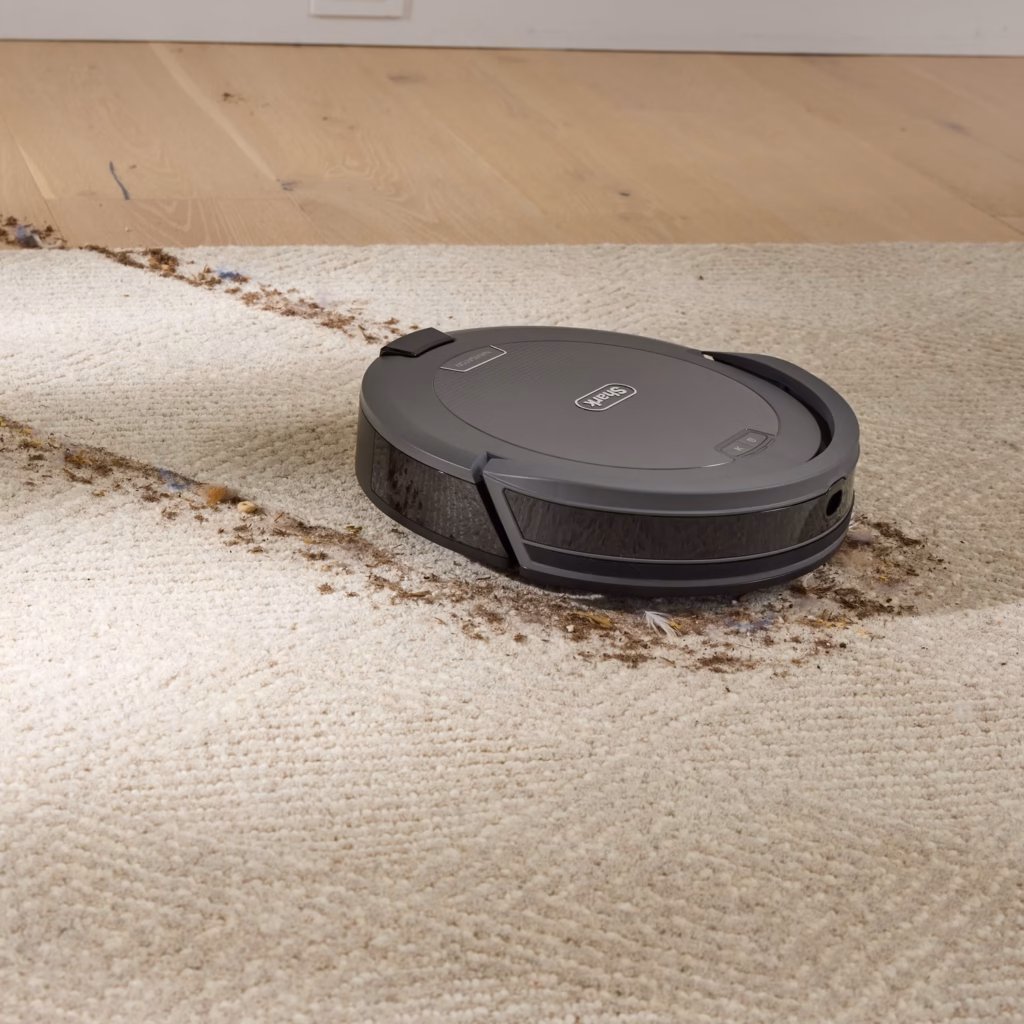 Shark Navigator RV2120AECA robot vacuum clearing debris from a carpet edge