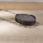 Shark Navigator RV2120AECA robot vacuum clearing debris from a carpet edge