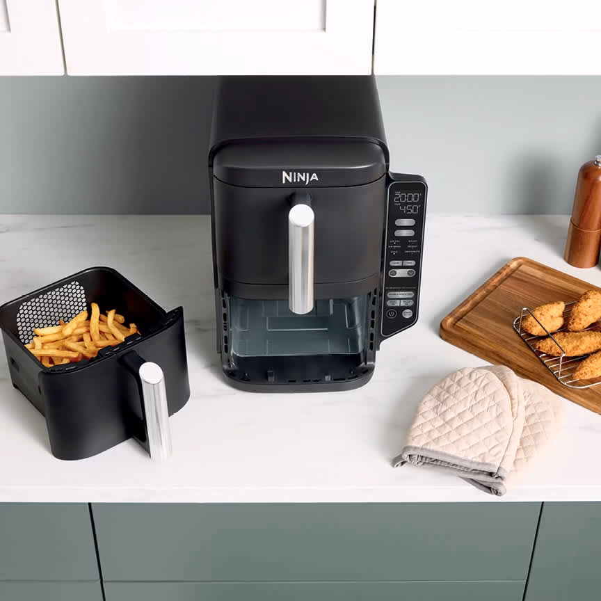 Ninja DoubleStack 2-Basket Air Fryer SL201C with a removed basket of fries, nonstick crisper plate and a stacked meal rack on the board