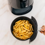 Ninja AF101C air fryer basket seen from above with a full load of French fries