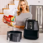 Ninja AF101C air fryer being loaded with frozen fries from the bag