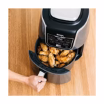 Ninja AF161C air fryer basket pulled open with golden chicken wings