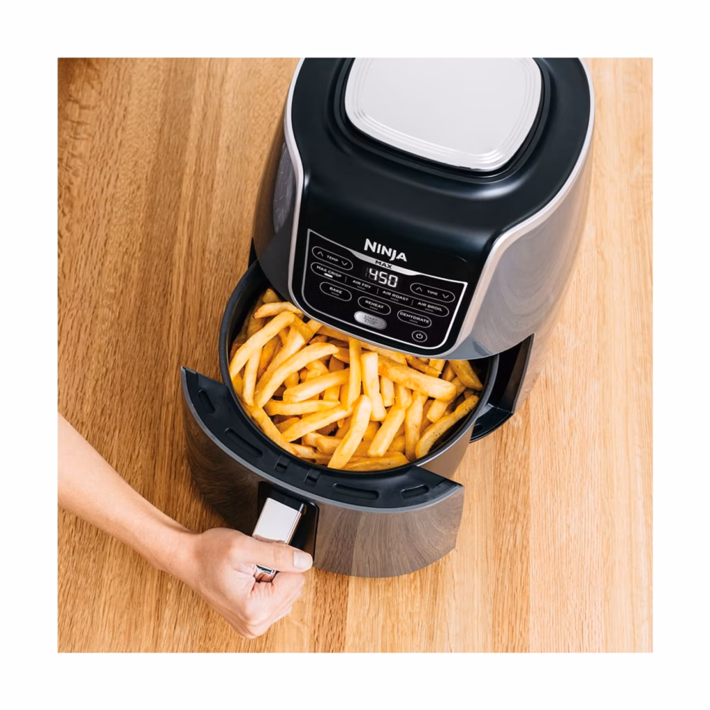 Ninja AF161C air fryer basket pulled open with a full load of crisp French fries