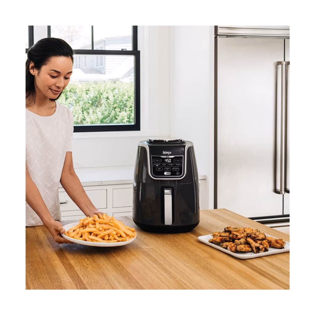 Ninja AF161C 5.5 qt grey air fryer on a kitchen counter beside a plate of fries