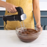 Ninja CI100C hand mixer attachment beating chocolate batter in a glass bowl