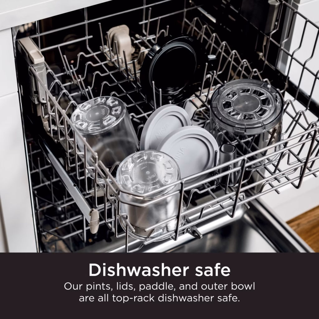 CREAMi pints, lids, paddle and outer bowl loaded on the top rack of a dishwasher