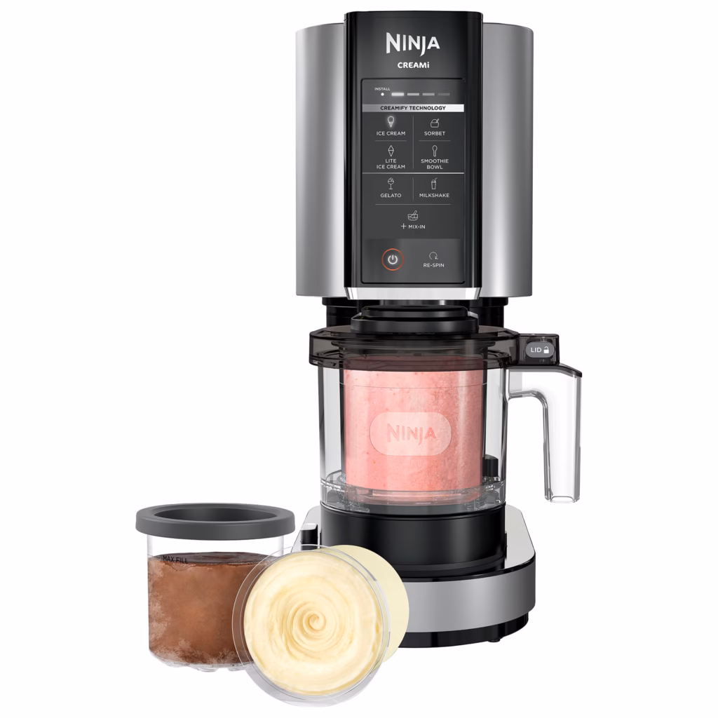 Ninja CREAMi NC301C with a processed pint in the bowl and two storage pints beside it