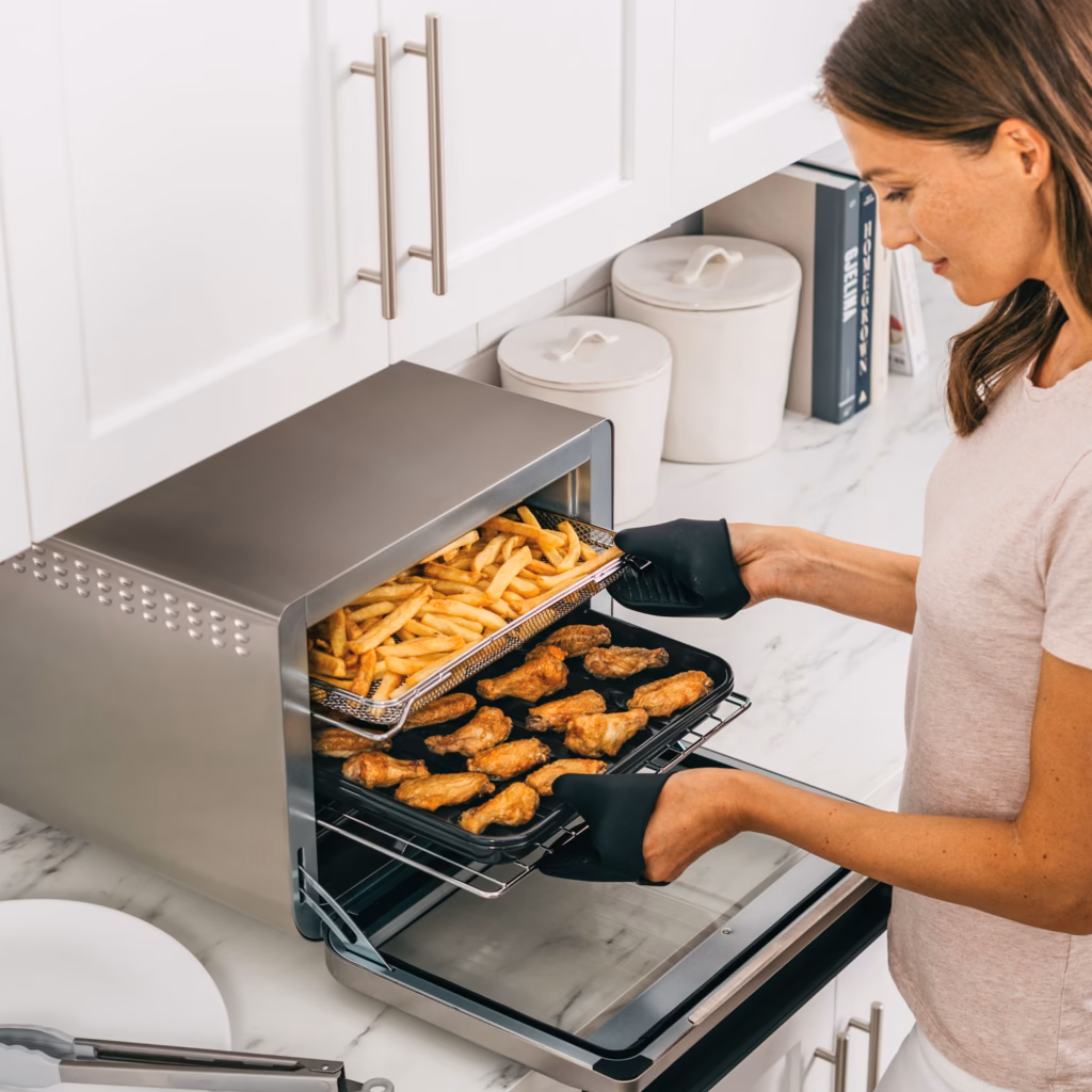 Ninja DT201C air frying a basket of fries on one level and chicken wings on the other