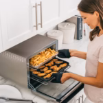 Ninja DT201C air frying a basket of fries on one level and chicken wings on the other