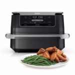 Ninja DZ071C FlexBasket air fryer front view with a plate of chicken wings and green beans