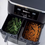Ninja DZ300C air fryer on a counter crisping kale chips and chickpeas in its two baskets