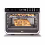 Ninja Foodi XL Pro Air Fry Oven DT201C in stainless steel with a whole roast chicken and a tray of vegetables cooking on two levels