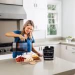 Ninja HB150C pouring a freshly blended sauce into a bowl on a kitchen counter