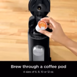 Ninja PB040C coffee maker with a coffee pod being loaded into the open brew head