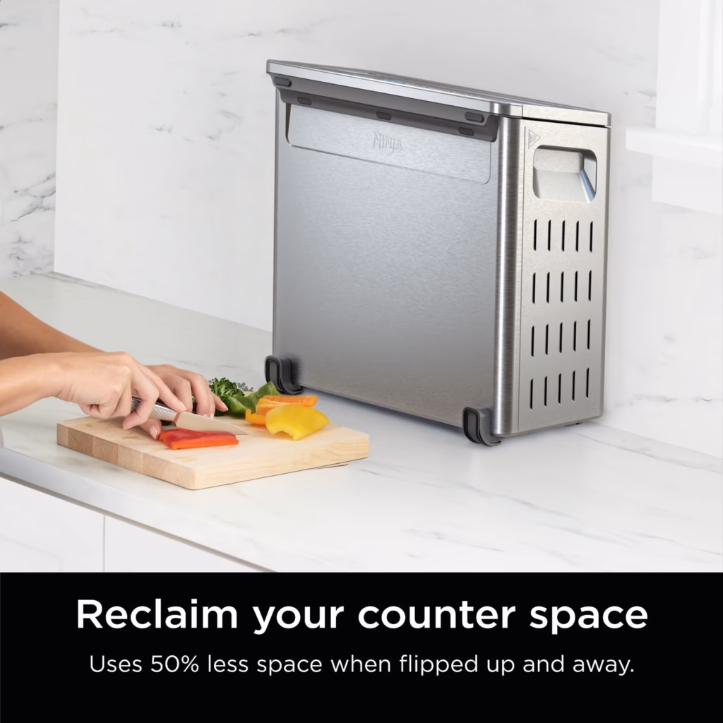 Ninja SP151C flipped up and stored upright beside a cutting board on the counter