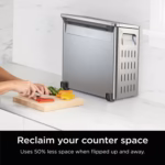 Ninja SP151C flipped up and stored upright beside a cutting board on the counter